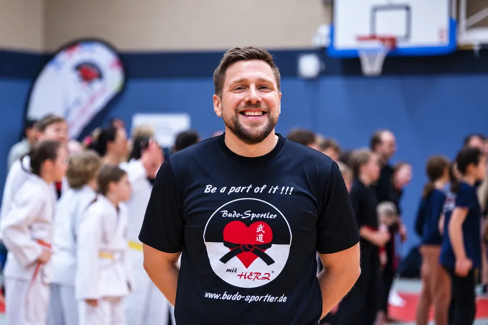 Timo Schröder, Krav Maga Kids Master Instructor, lächelnd in einer Sporthalle